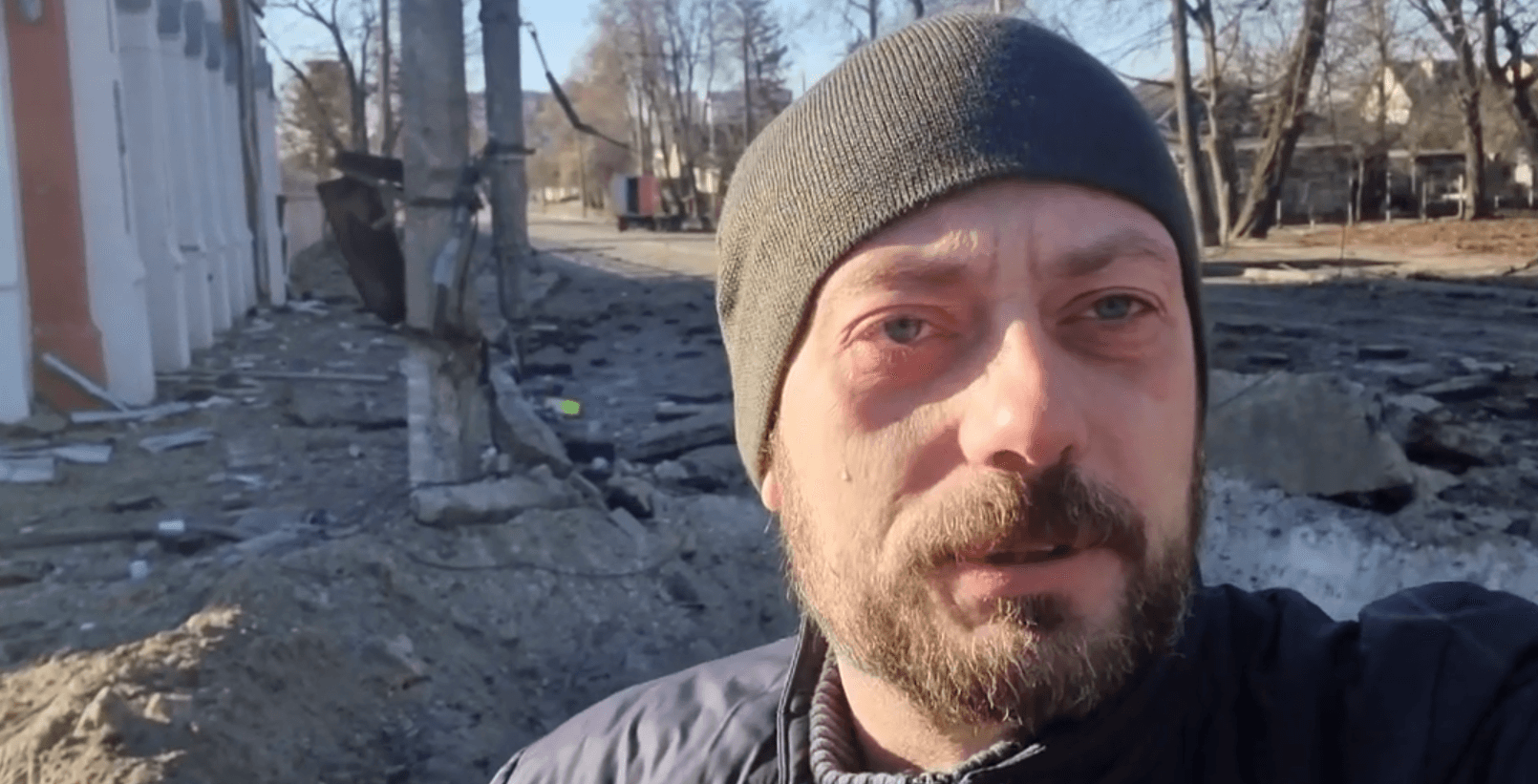 Вячеслав Чаус рядом с воронкой перед библиотекой