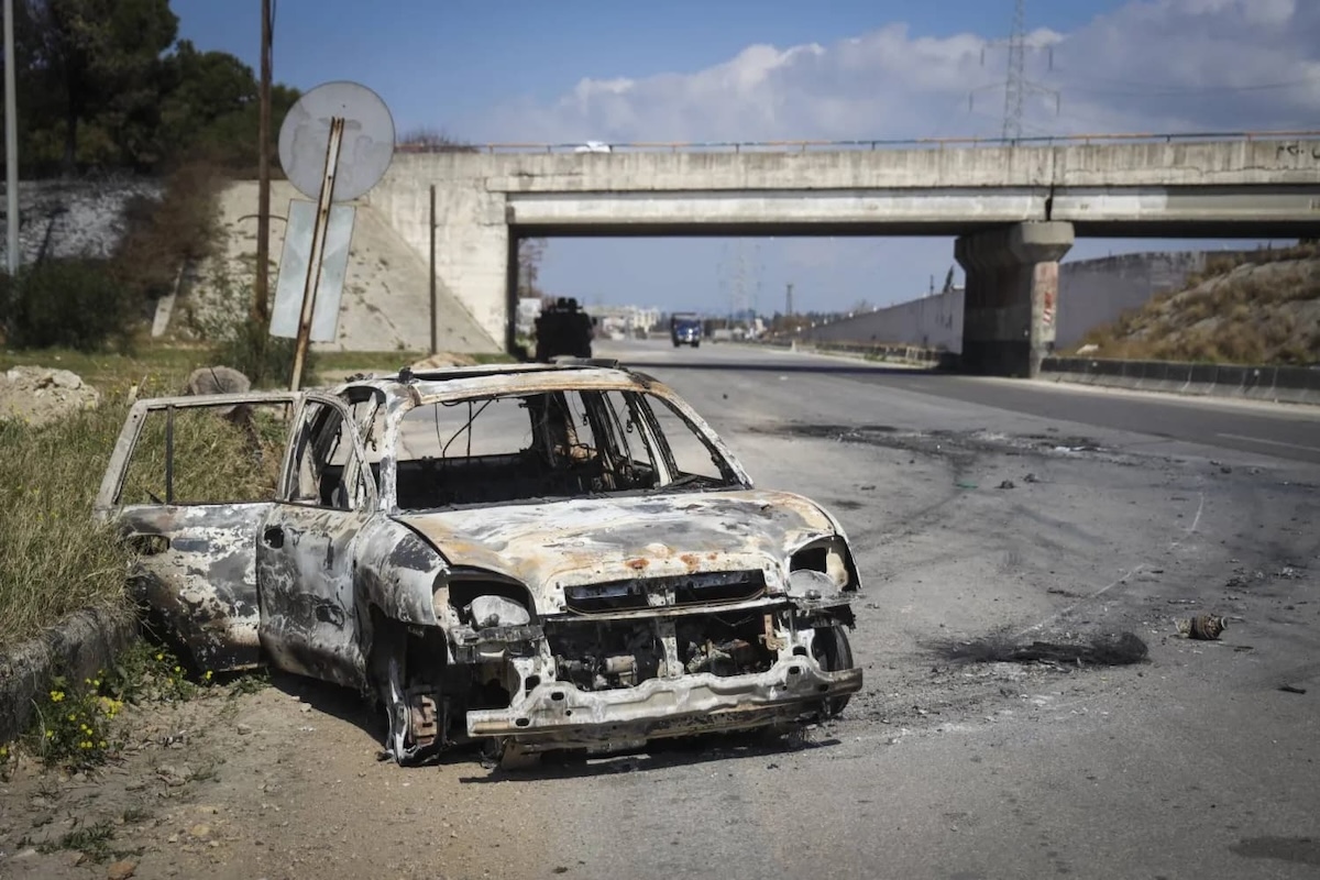 Сожженный в ходе столкновений в Латакии автомобиль. Фото: AP